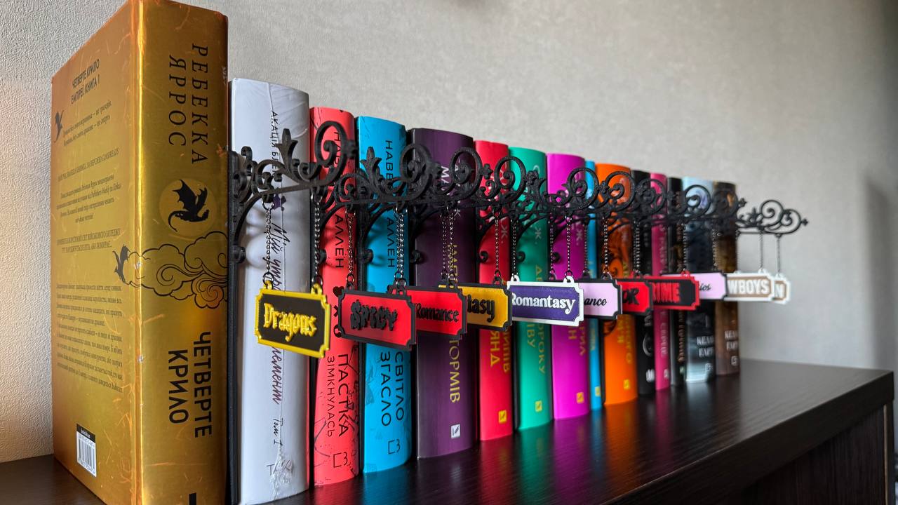 Табличка-вказівник жанру на кронштейні між книжками